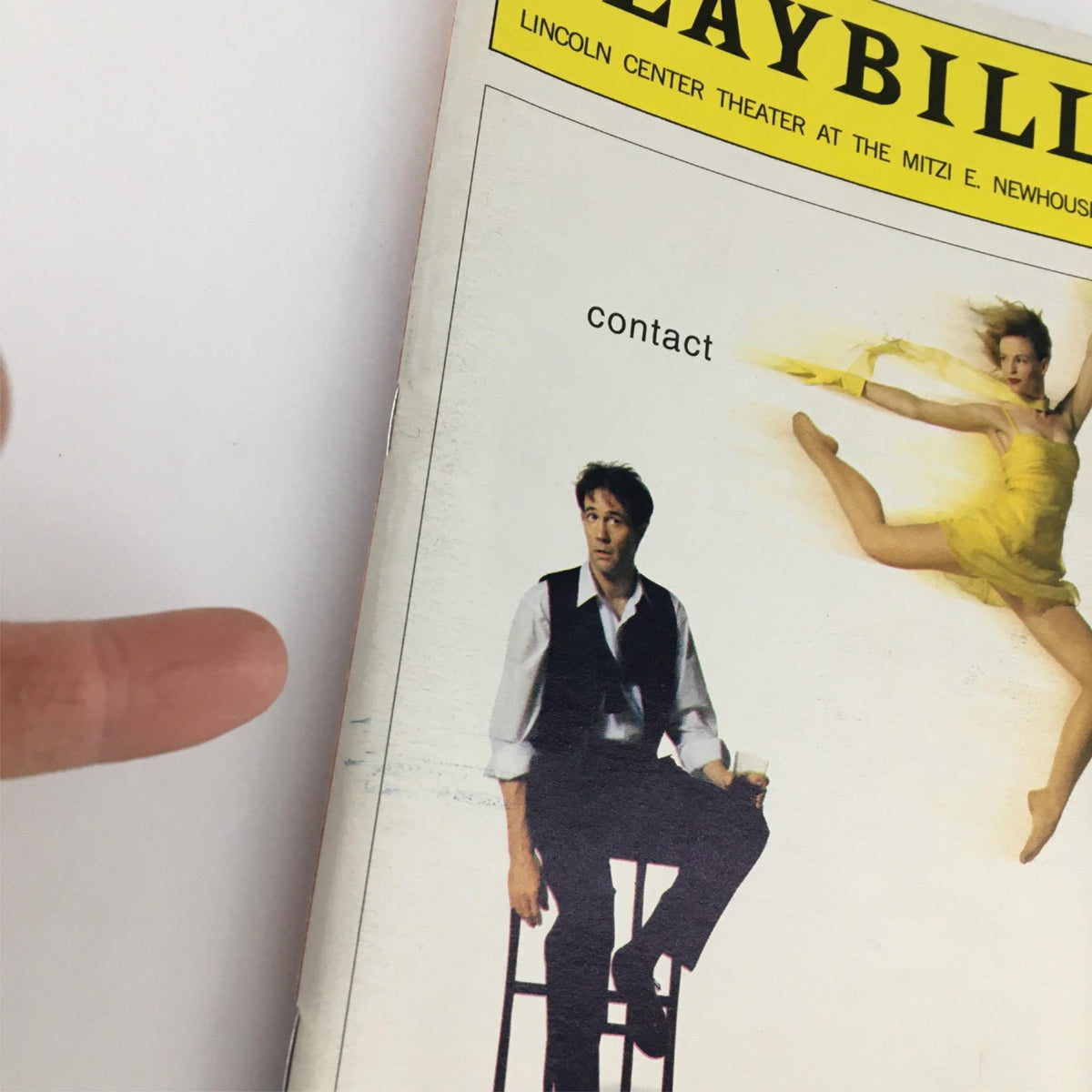 Close-up of the 1999 Playbill for 'Contact' by Lincoln Center Theater, highlighting the title and images of cast members.