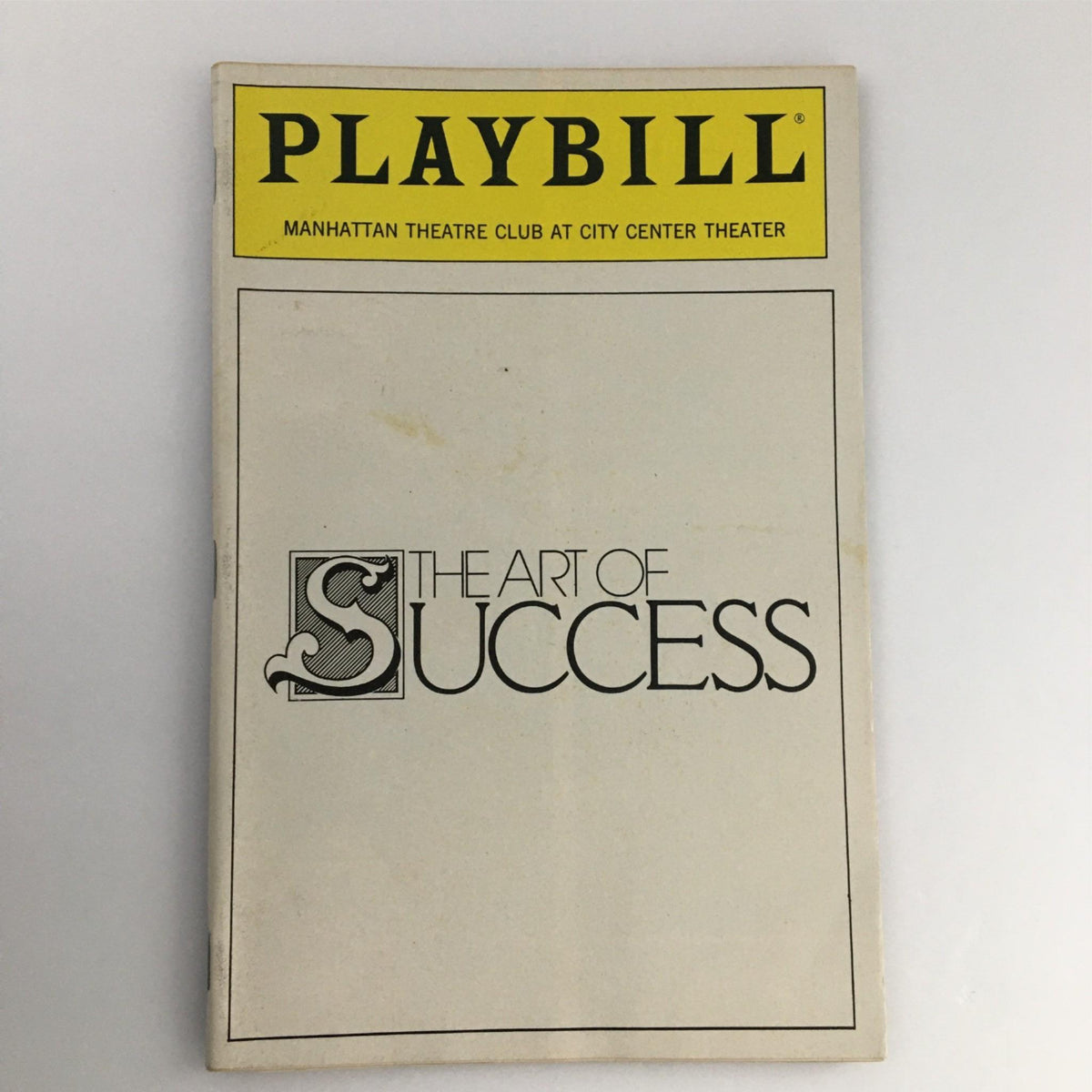 Front cover of the 1990 Playbill for The Art of Success by Manhattan Theatre Club, showcasing its distinctive logo and title.