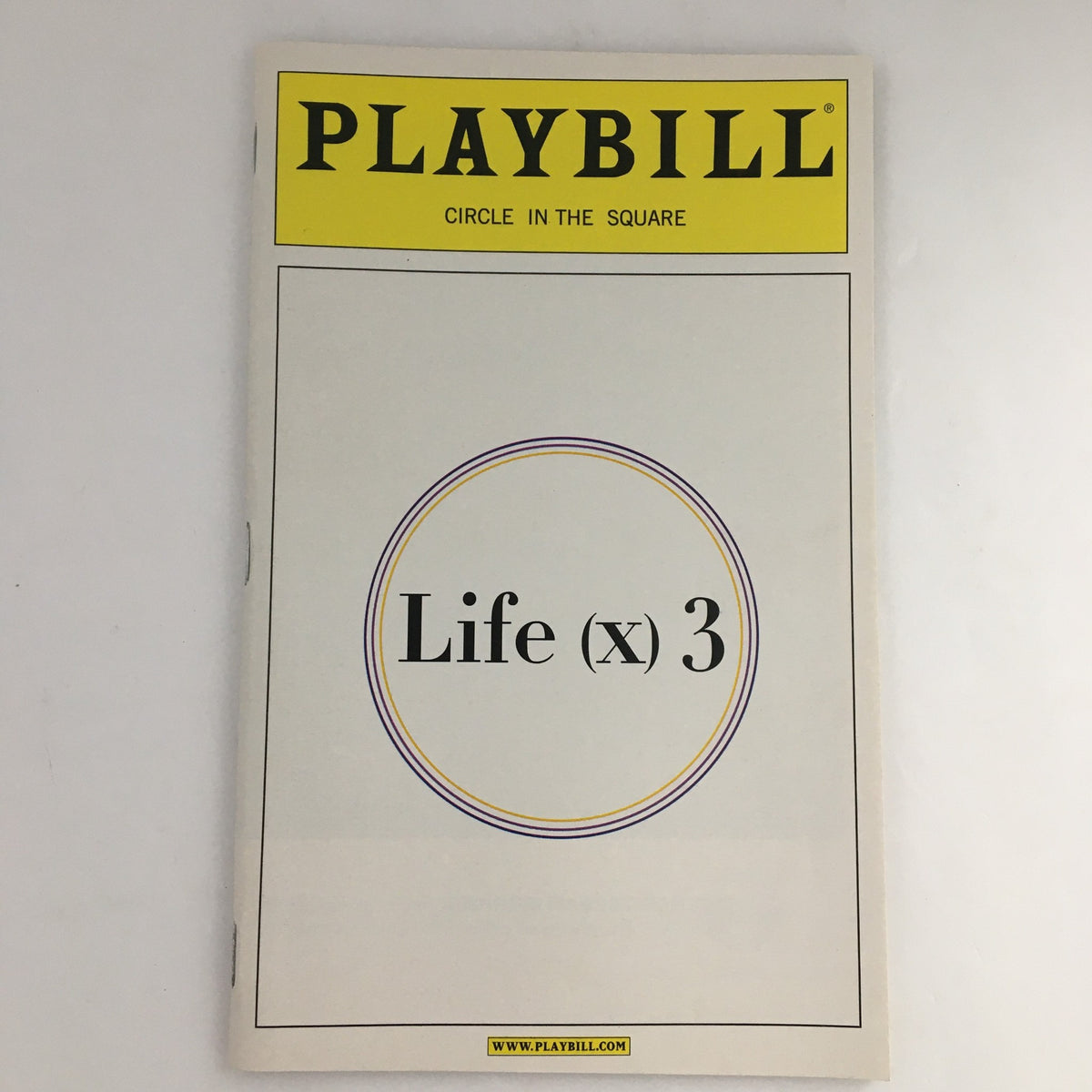 Cover of the 2003 Playbill for 'Life x 3' presented at Circle in the Square, featuring a simple design and title.