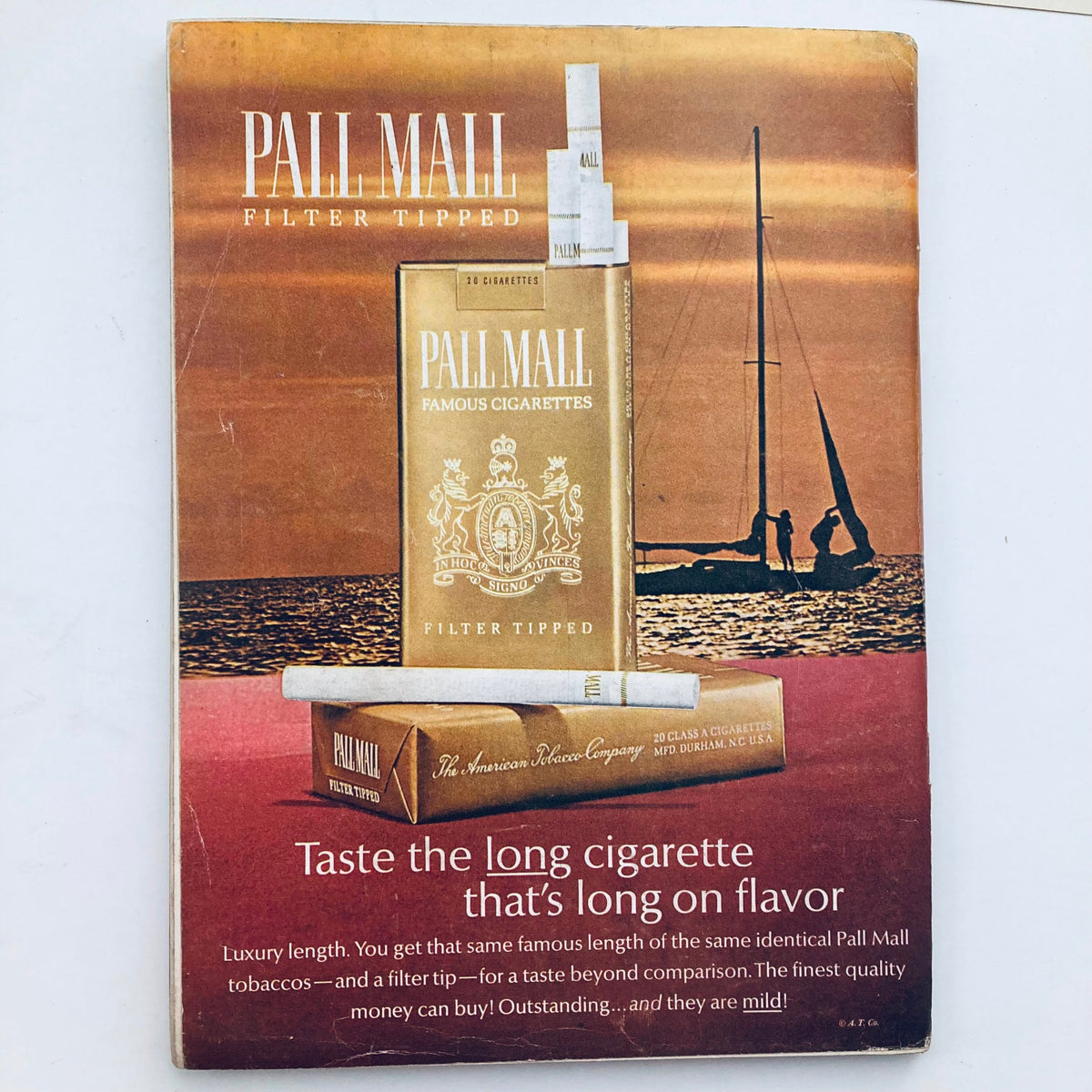 Vintage advertisement for Pall Mall cigarettes showcasing a pack against a serene beach backdrop.