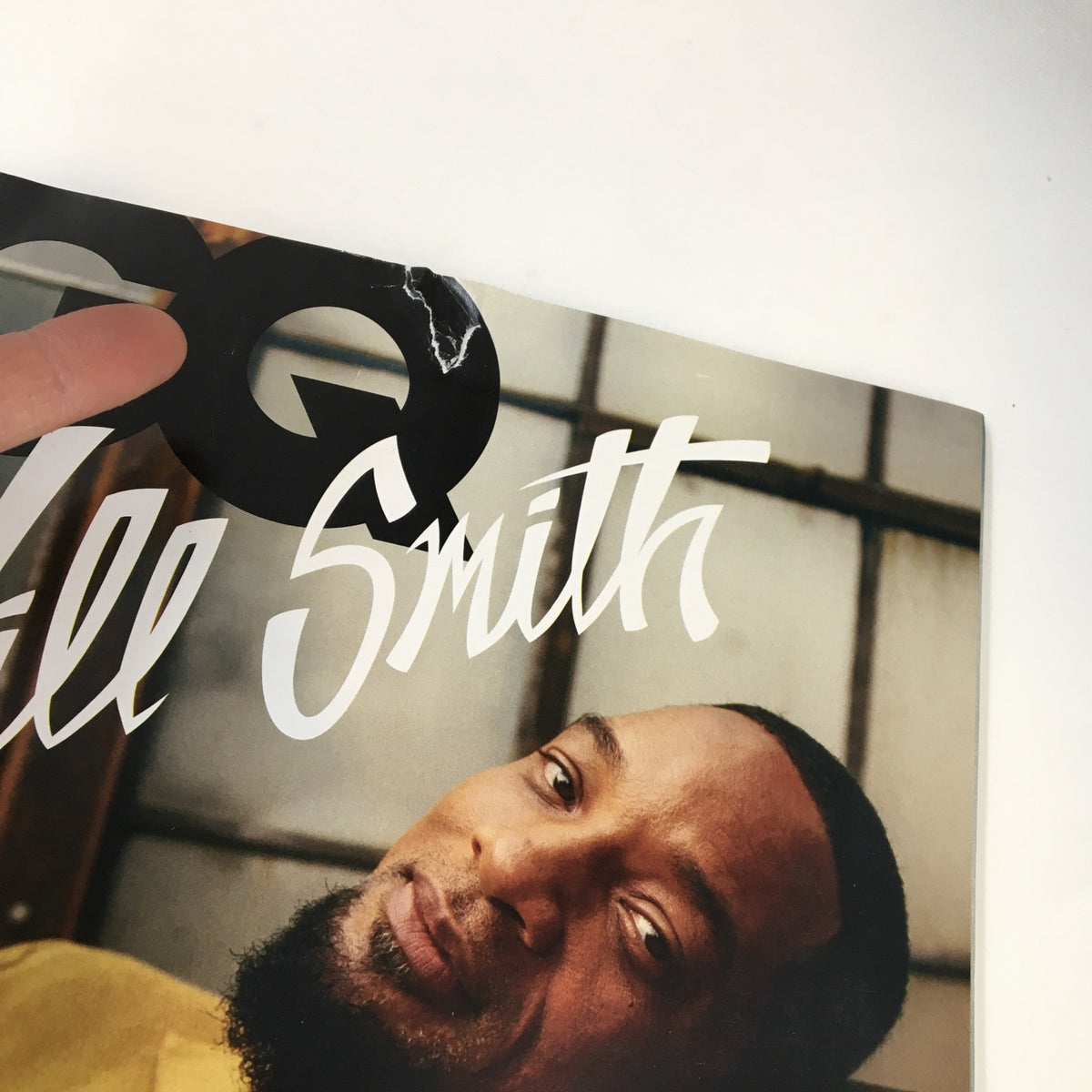 Close-up detail of GQ Magazine November 2021 cover with Will Smith, highlighting the title and a minor defect at the corner, underscoring the magazine's vintage charm.