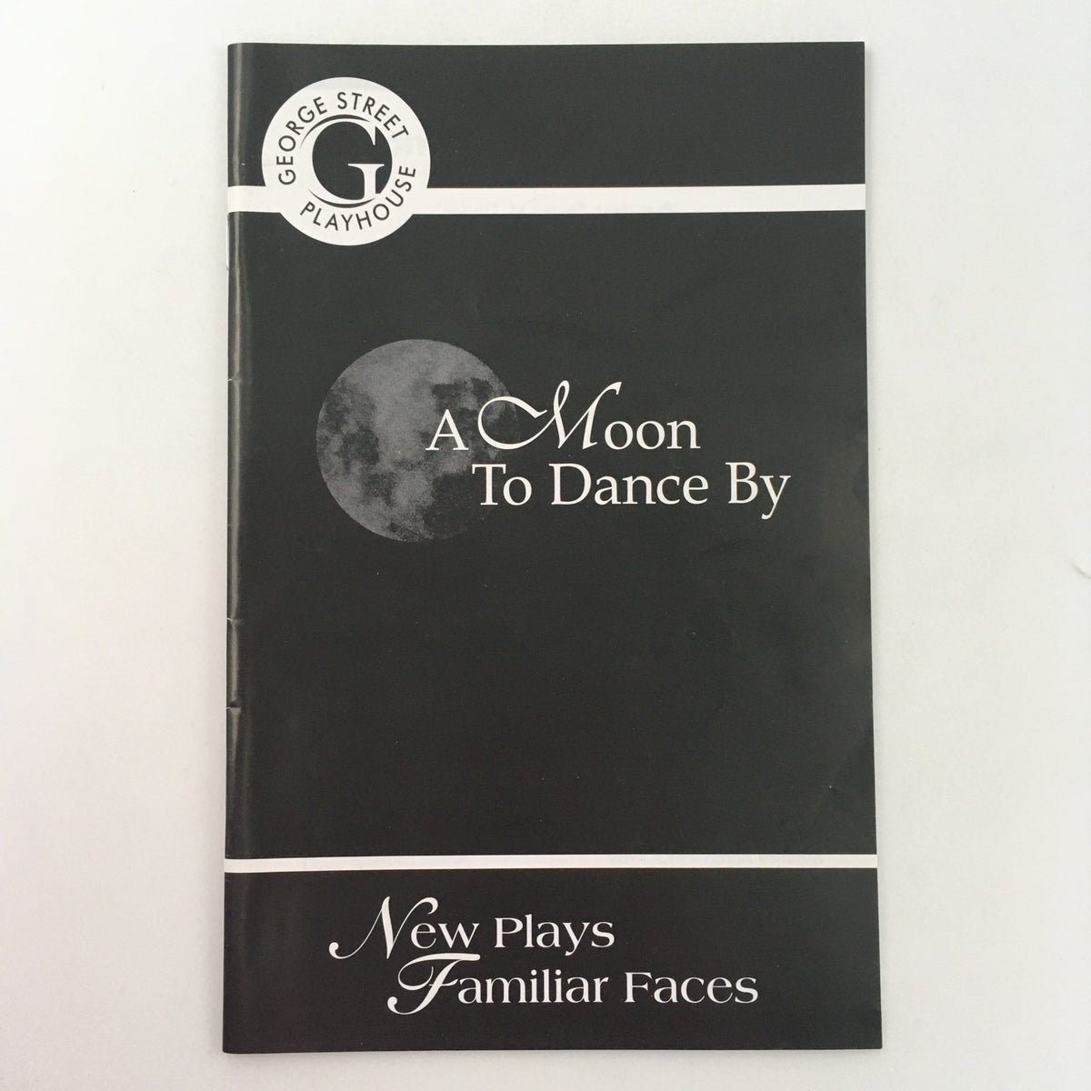 Cover of 'A Moon To Dance By' by Thom Thomas, featured in the 2009 George Street Playhouse premiere. The design showcases a moon graphic and highlights the title along with the tagline 'New Plays Familiar Faces.'