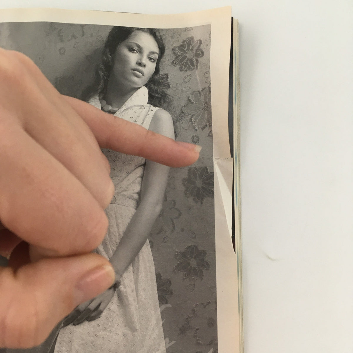 Detailed view of a page from the 2006 Playbill for 'Awake and Sing!' by Clifford Odets, featuring a hand pointing to a black-and-white photograph of a young woman.