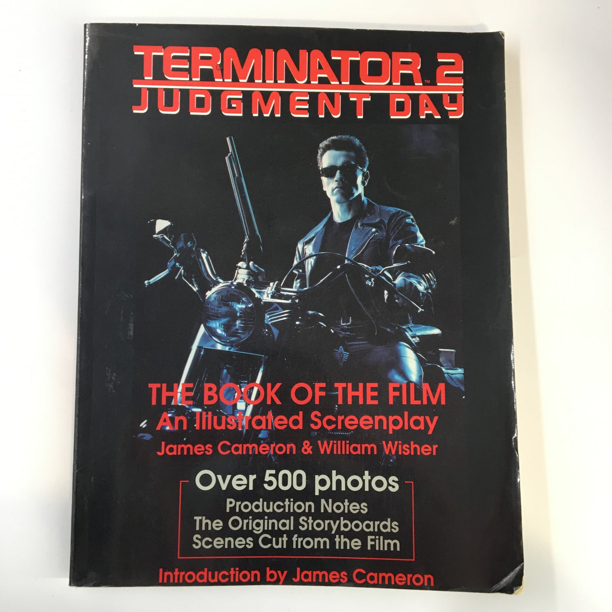 Cover of '1991 Terminator 2 Judgement Day The Book of The Film An Illustrated Screenplay' showing the main character on a motorcycle, by James Cameron and William Wisher.