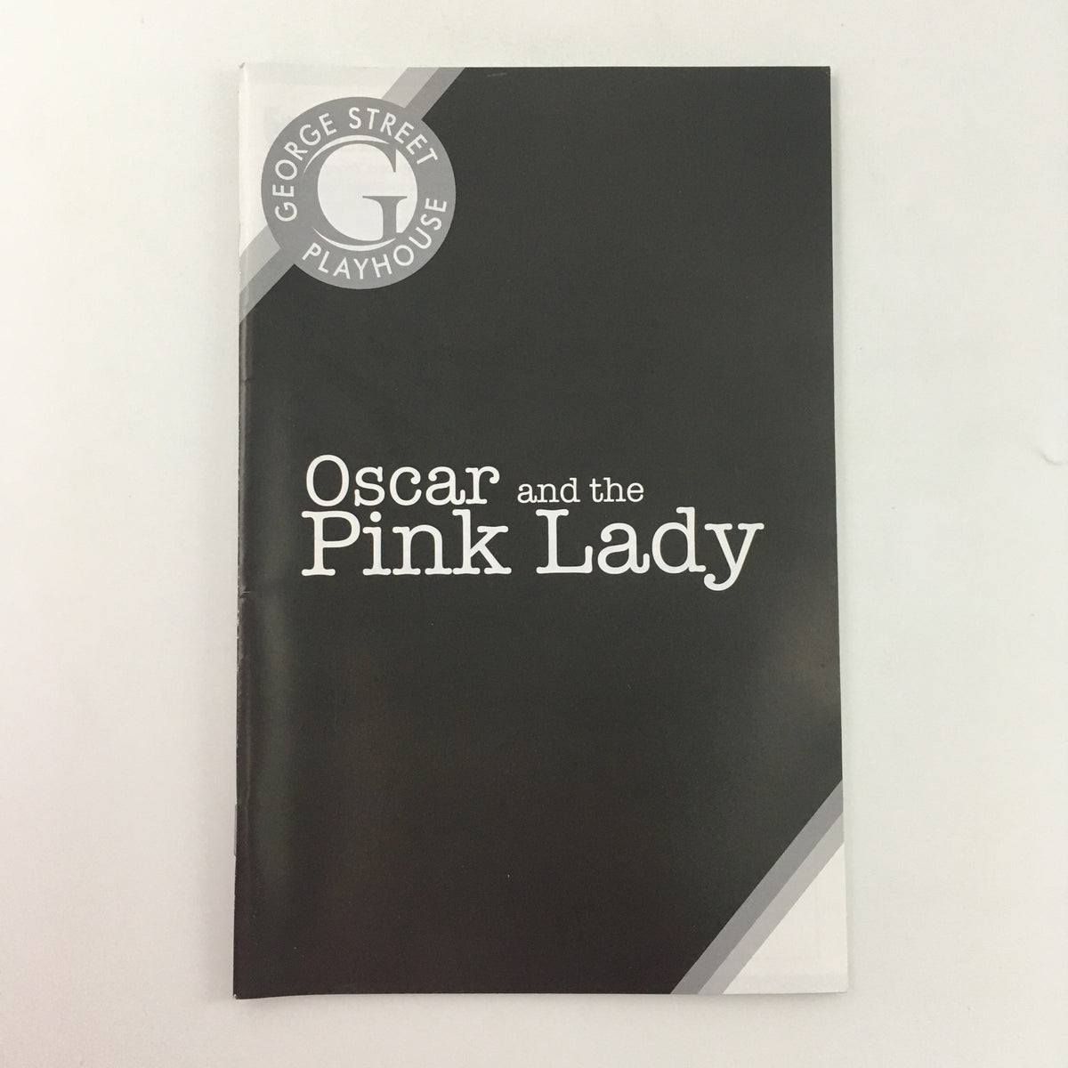 Cover of the 2008 George Street Playhouse production of 'Oscar and the Pink Lady' by Eric-Emmanuel Schmitt, featuring a stylish black design with white text.