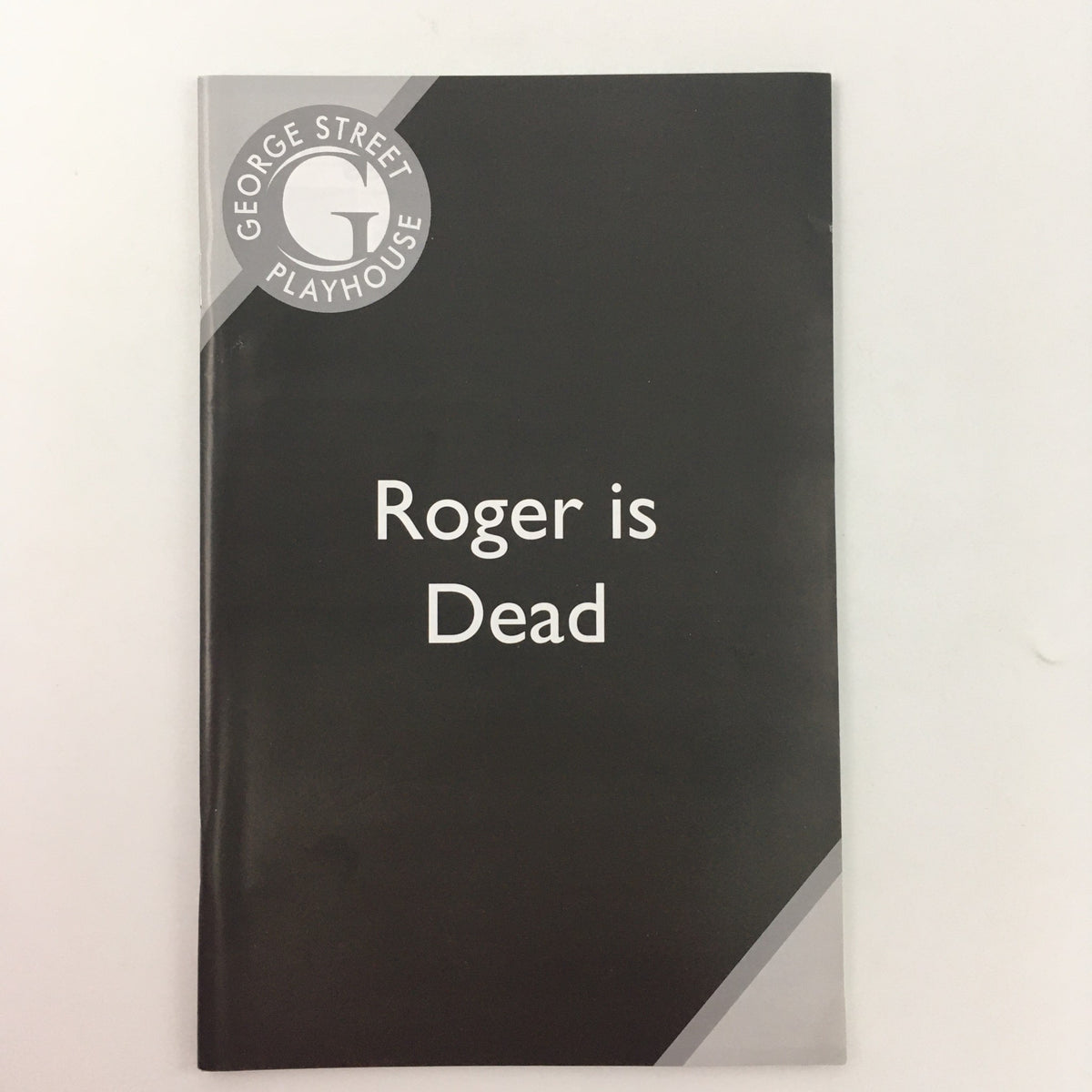 Cover of the 2008 George Street Playhouse production of ‘Roger is Dead’ by Elaine May, featuring a sleek black design with the theater logo.