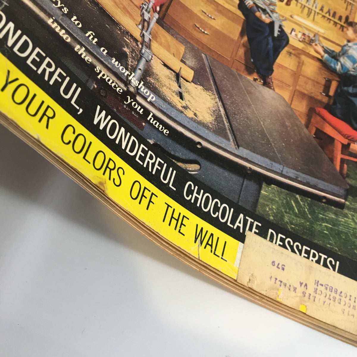 Snapshot of the bottom part of the cover of VTG Household Magazine October 1956, highlighting colorful advertisements and the focus on workshop organization and home decor tips.