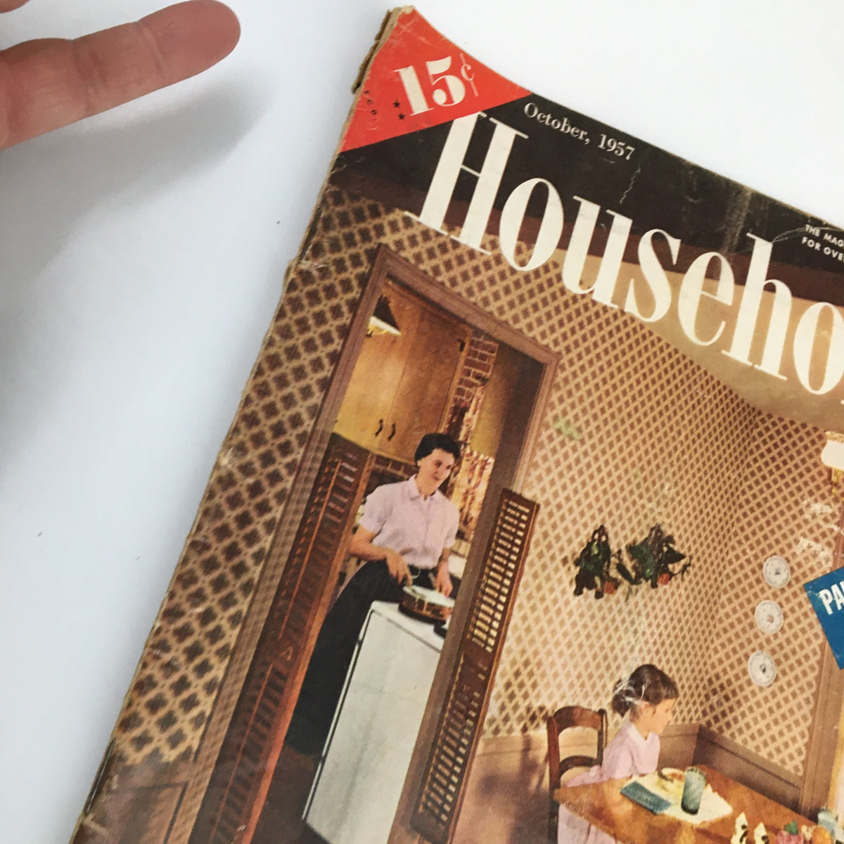 Detail view of the cover of VTG Household Magazine October 1957, highlighting a woman in the kitchen and nostalgic elements of mid-century American design.