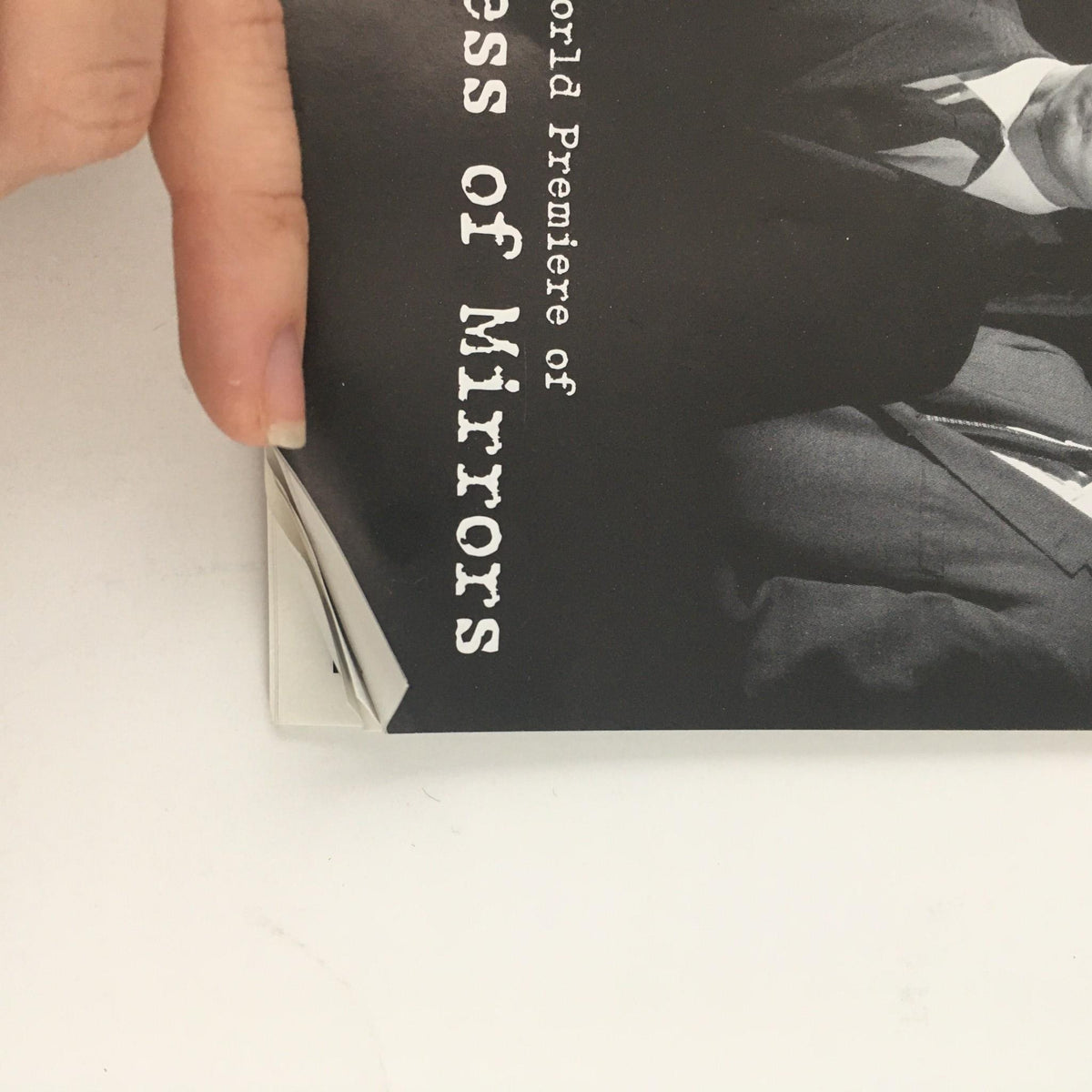 Close-up of the corner of 'Wilderness of Mirrors' program, highlighting a bent corner, indicating its very good condition.