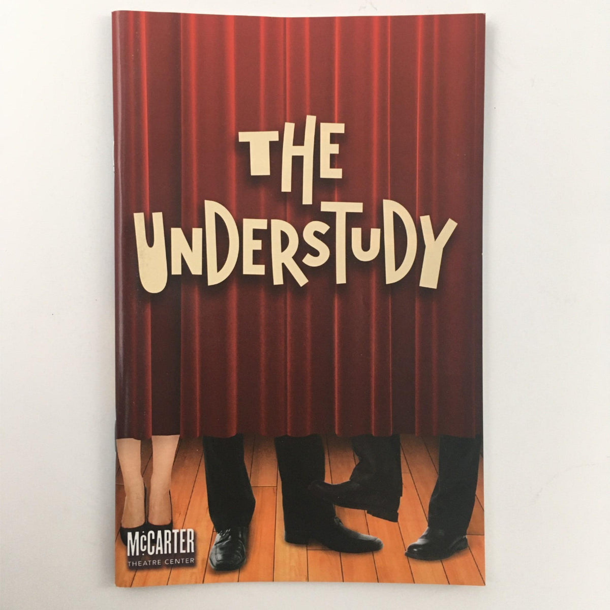 Cover of 'The Understudy' pamphlet from McCarter Theatre Centre, showcasing the title 'THE UNDERSTUDY' with a red curtain motif.