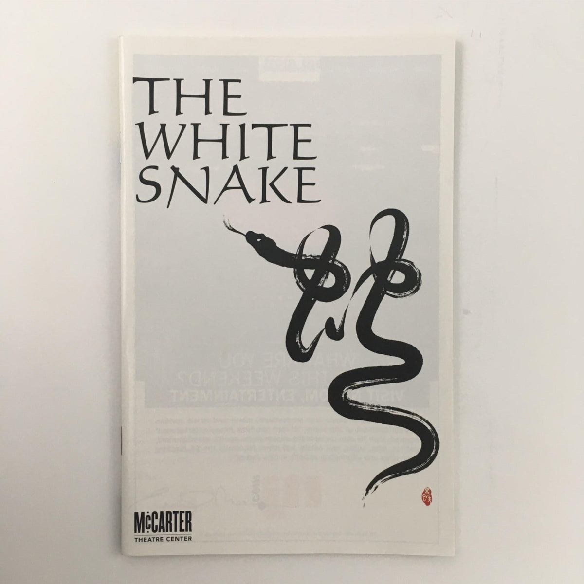 Cover of 'The White Snake' by Mary Zimmerman and Emily Mann, featuring an artistic black snake design, showcased at McCarter Theatre Center.