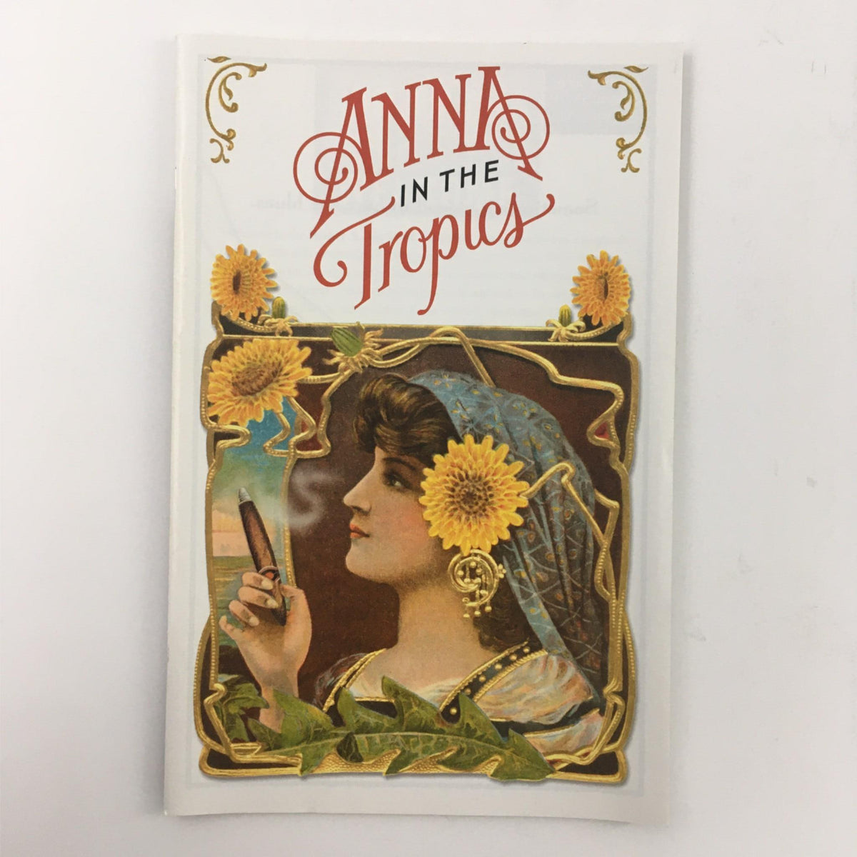 Front view of the book 'Anna in the Tropics', showcasing the title along with an illustration of a woman adorned with sunflowers. This is related to the 2003 theater production by Nilo Cruz and Emily Mann.