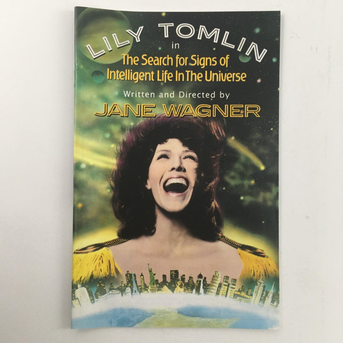 2000 The Search for Signs of Intelligent Life in the Universe by Jane Wagner featuring Lily Tomlin on the cover, showcasing vibrant cosmic background and theatrical elements, highlighting its themes.