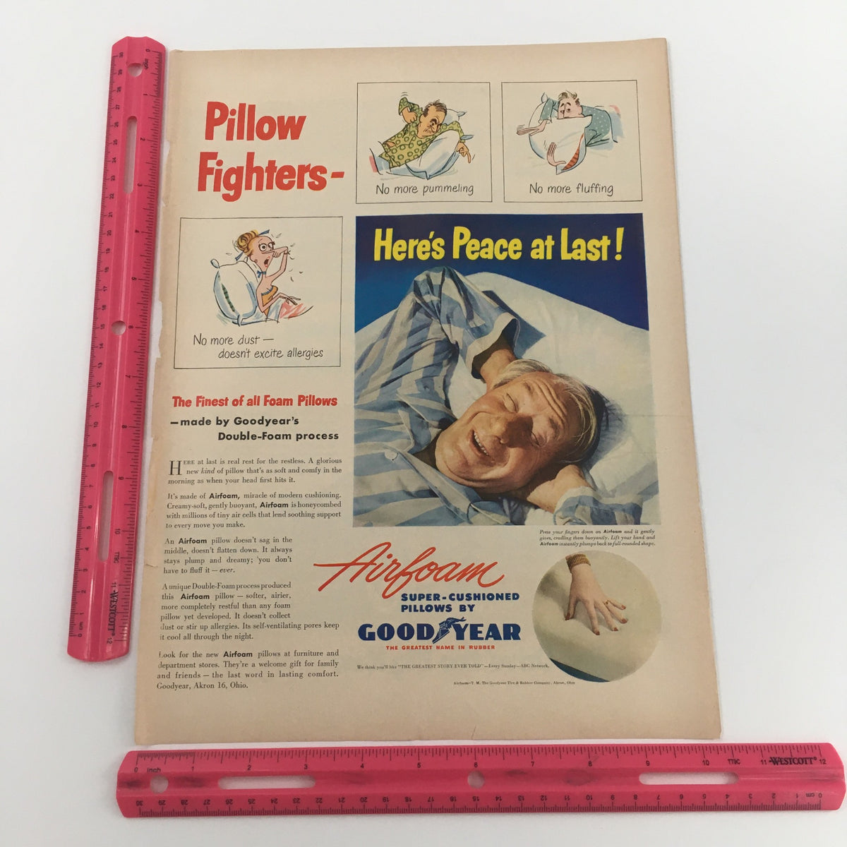 Close-up view of a vintage Goodyear pillow advertisement featuring a relaxed man sleeping peacefully, promoting Airfoam Super-Cushioned Pillows with a focus on comfort.