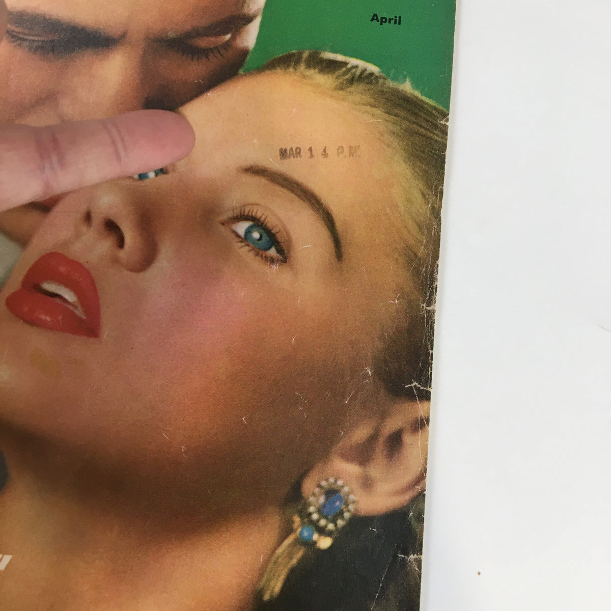 Close-up of the cover of True Confessions Magazine April 1953, showing the detailed facial features of a woman with striking blue eyes and bold red lips, along with a date stamp indicating March 14.