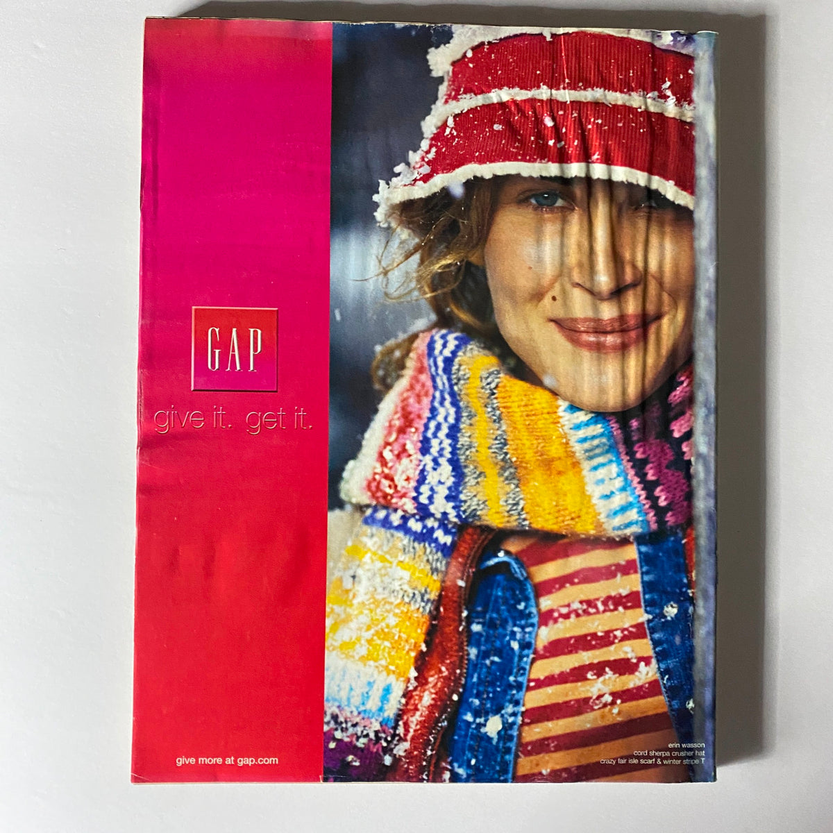 Ad page from W Magazine December 2003 for GAP, featuring a cozy winter fashion look with vibrant colors and a festive style.