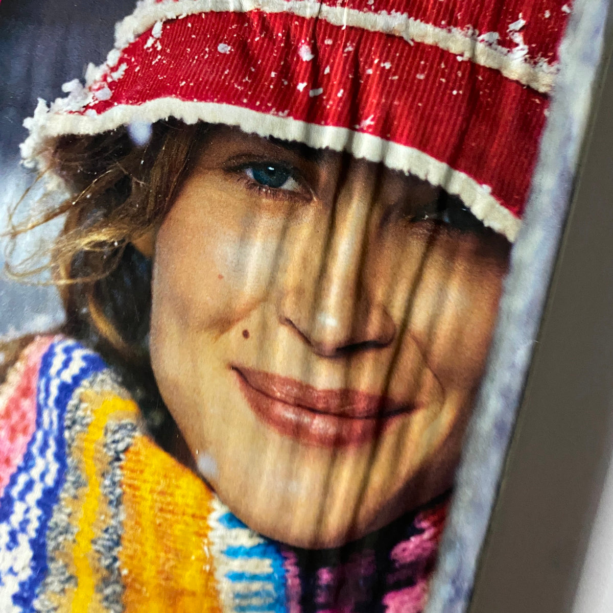 Close-up image of a model in a winter fashion advertisement from W Magazine December 2003, showcasing a candid and cheerful expression.