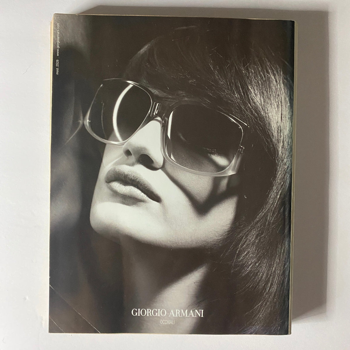 Giorgio Armani advertisement displaying a stylish black-and-white portrait of a model wearing sunglasses, emphasizing high fashion and elegance, from the W Magazine September 2001 issue featuring Golden Gwyneth Paltrow on the cover.