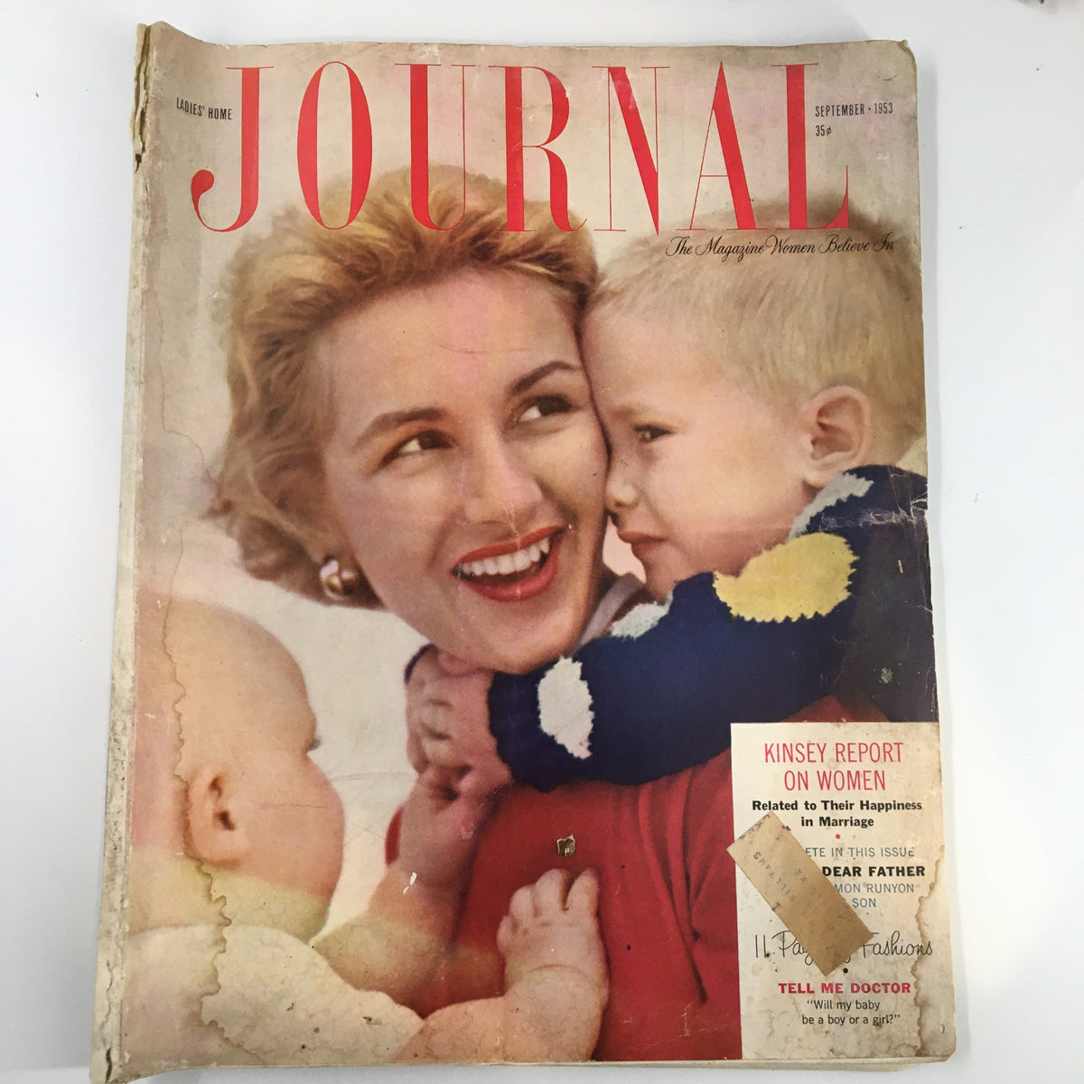 Cover of Ladies' Home Journal Magazine from September 1953, featuring a smiling woman with two children. The headline 'JOURNAL' is prominent, along with a mention of 'Kinsey Report on Women' and other features. This issue includes the 3rd part of 'The Enchanted Cup,' making it a collectible piece reflecting mid-20th century family life.