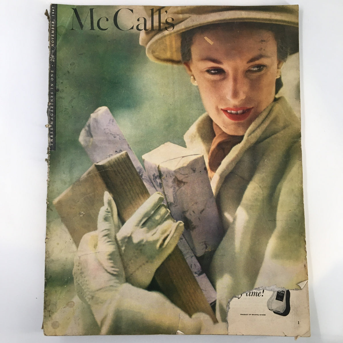 Vintage McCall's Magazine cover from November 1947 featuring a woman in a hat and gloves, holding wrapped gifts, reflecting the style and social themes of the era. Marry for Money Part Two of Four.