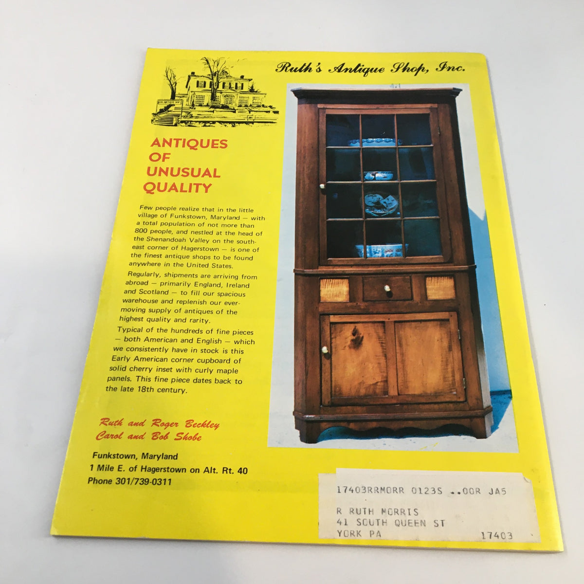 Back cover of Spinning Wheel Magazine July-August 1973 promoting Ruth's Antique Shop, featuring a wooden display cabinet filled with ceramics.