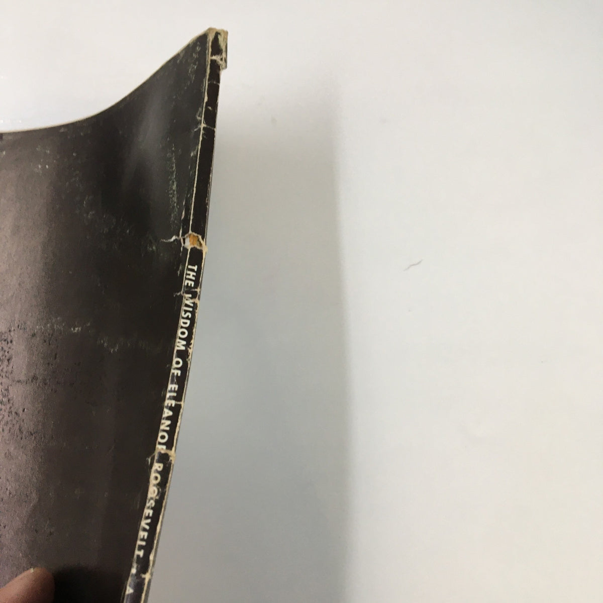 Close-up view of the spine of the book '1962 A Tribute To The Wisdom of Eleanor Roosevelt', showing some wear and vintage character.