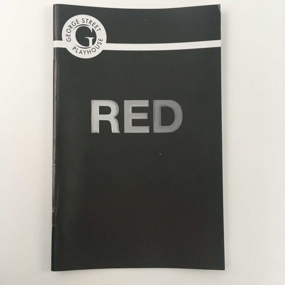 Alternate view of the 2012 George Street Playhouse Red program cover showcasing the title 'RED' prominently, reflecting the theater's branding.