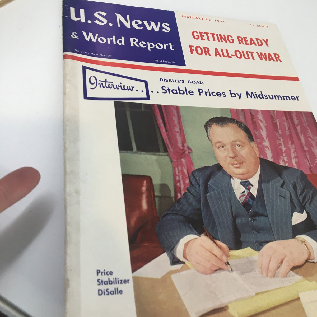 Close-up of the cover of U.S. News & World Report Magazine, February 16, 1951, 'Getting Ready For All-Out War,' showing a man dressed in a suit writing notes, surrounded by a colorful background.