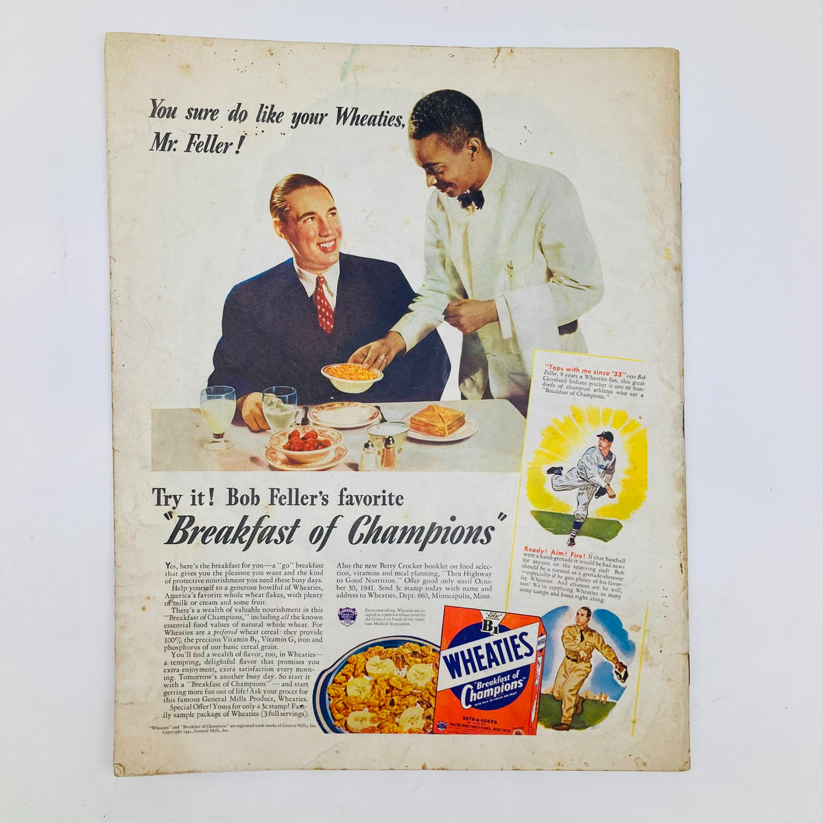 Vintage advertisement featuring Bob Feller enjoying Wheaties breakfast, emphasizing its title 'Breakfast of Champions'. The scene depicts Feller smiling at a waiter serving him cereal, capturing the charm of 1940s branding and nostalgia.