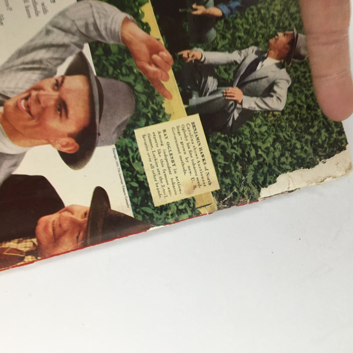 Detail of the back cover of the Newsweek Magazine dated November 6, 1939, showing an advertisement with a group of men in a tobacco field promoting Lucky Strike cigarettes, with signs of age and use.