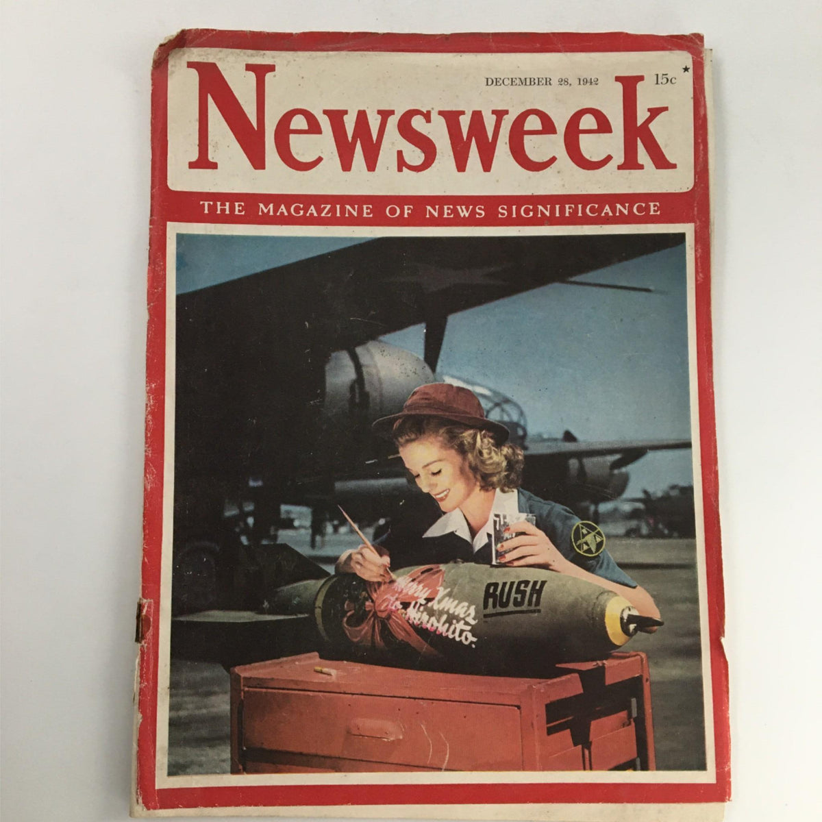 Cover of Newsweek Magazine December 28, 1942 featuring a woman painting a bomb with the inscription 'Merry Xmas to Hirohito', depicting wartime efforts during World War II.
