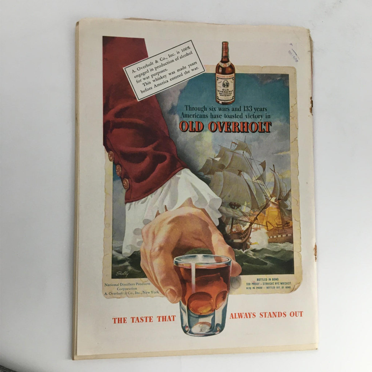 Vintage advertisement for Old Overholt whiskey from a 1943 issue of Newsweek Magazine, showcasing a hand holding a glass and an artistic depiction of a ship and colonial attire. This ad reflects the historical context of the time, complementing the featured article on General Chennault and the Flying Tigers.