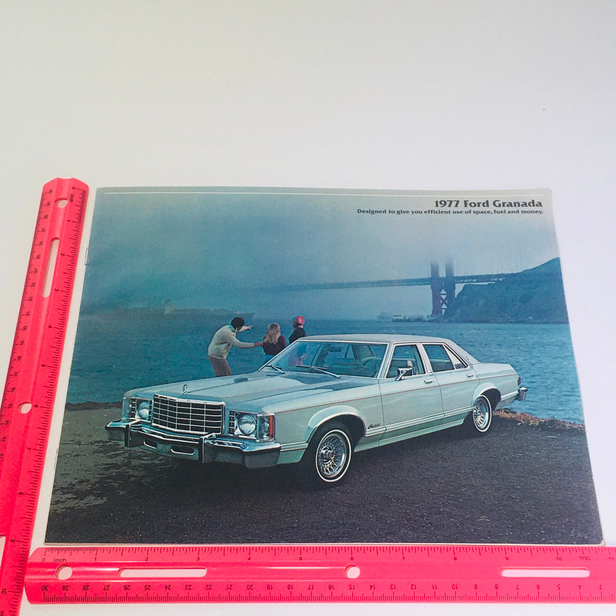 Cover of the Vintage 1977 Ford Granada 12-page Original Car Sales Brochure Catalog displaying a 4-Door Granada by the waterfront with individuals in the background.
