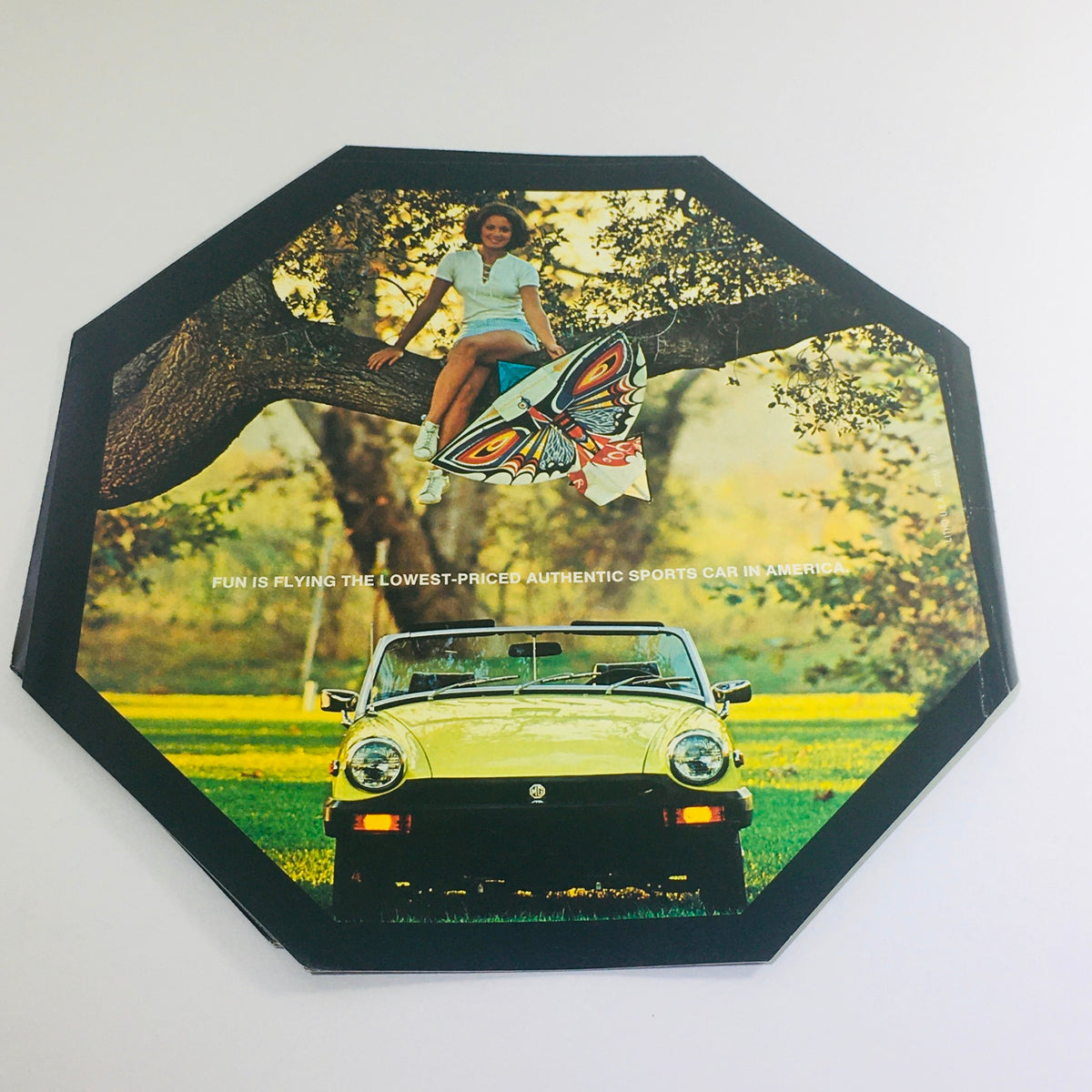 1977 MG Midget Octagon Go Fly A Midget Auto Car Sales Catalog Brochure page showcasing a young woman perched on a tree with a butterfly kite and a green MG Midget car.