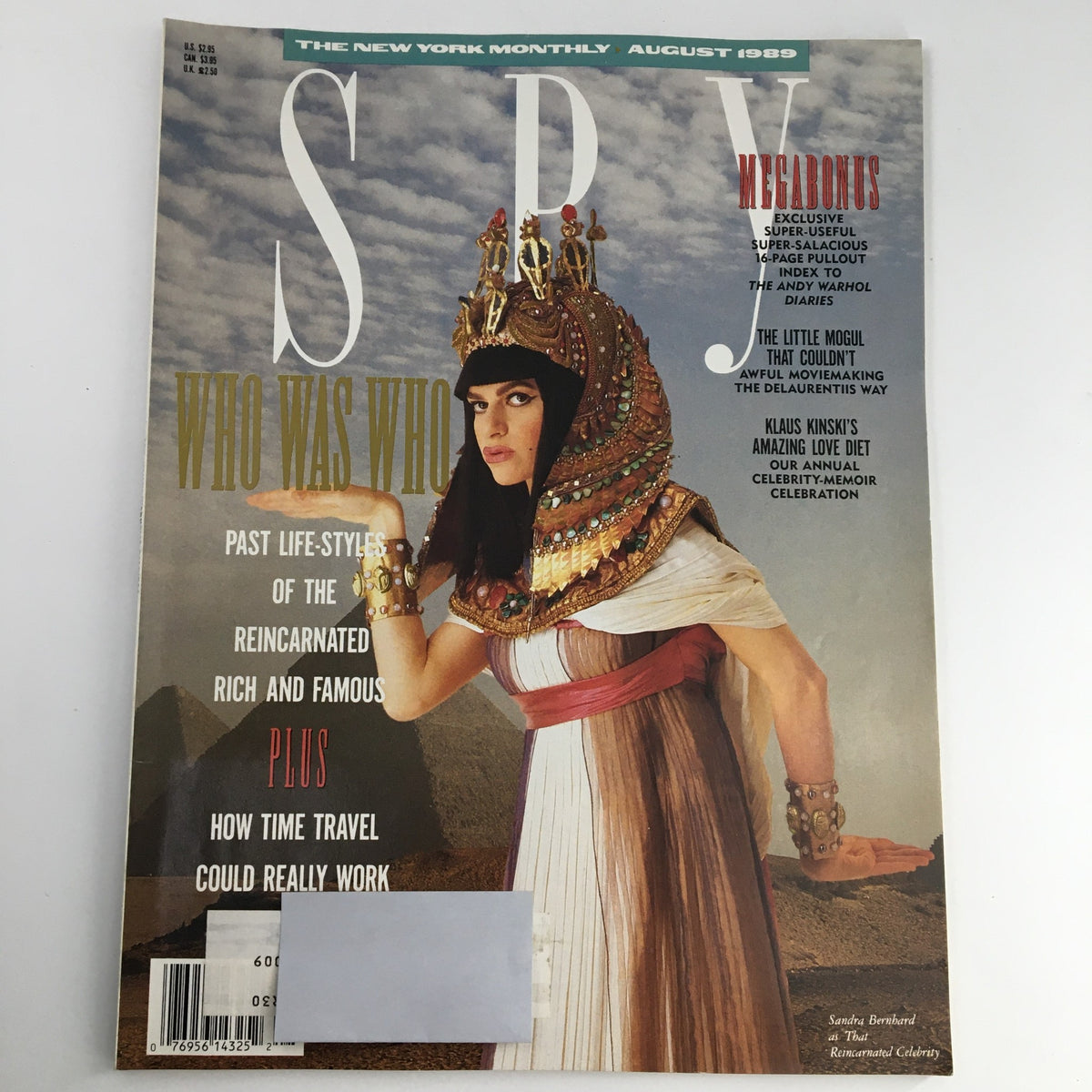 Cover of Spy Magazine August 1989 featuring Sandra Bernhard in a dramatic pose, adorned with a regal headdress, promoting the Andy Warhol Diaries feature. The cover includes the tagline 'Who Was Who' and discusses topics like reincarnated rich and famous individuals.