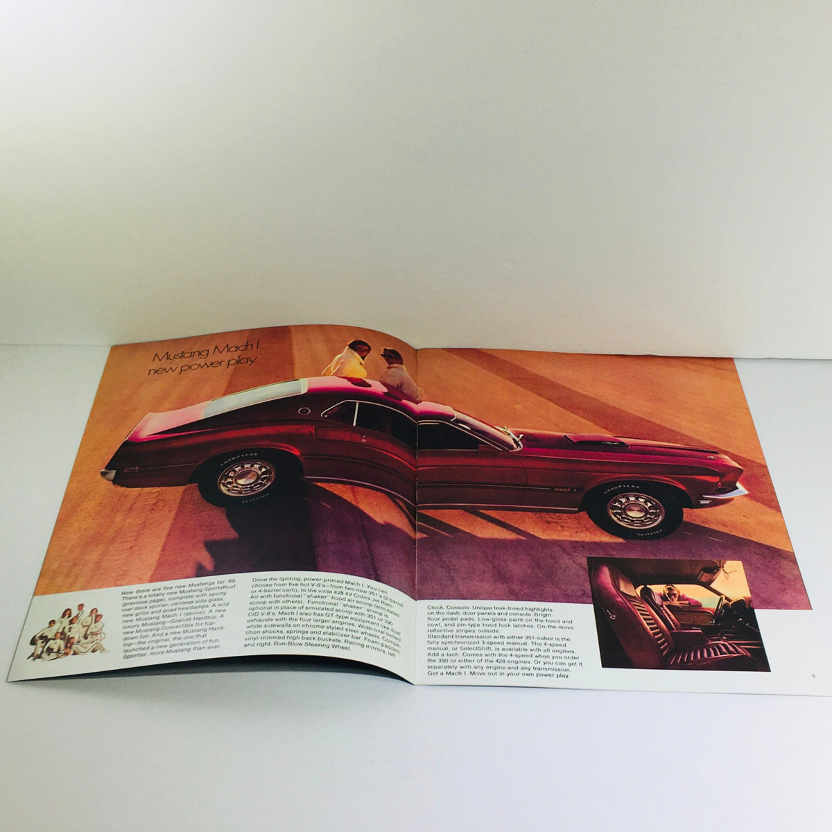 Vtg 1969 Ford Mustang Mach Hardtop Sedan 428 4-V Cobra Engine Auto Car Brochure showcasing the sleek design and power of the vehicle within a colorful advertisement layout.