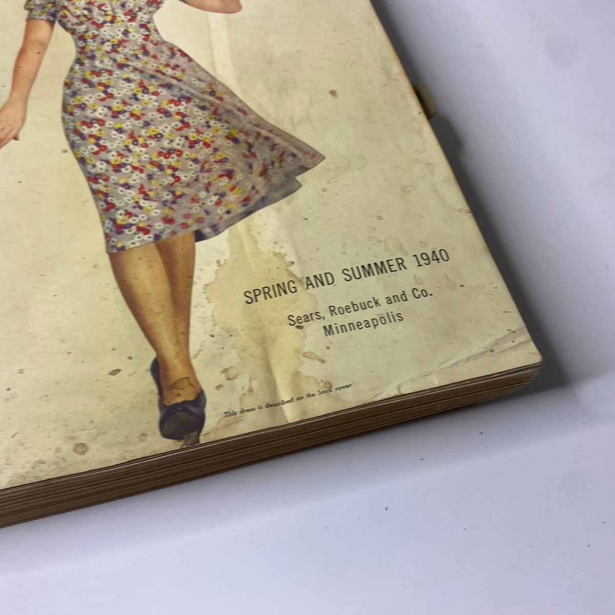 Close-up view of the cover of the 1940 Sears Spring and Summer Catalog, displaying the title and a woman in a floral dress.