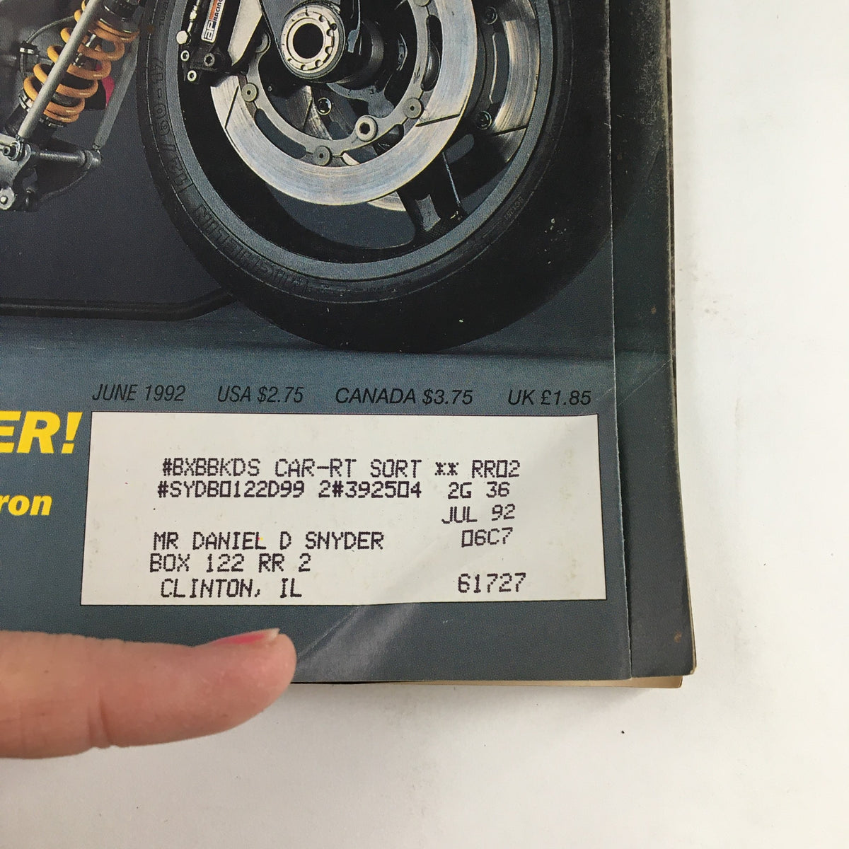 Cycle World Magazine June 1992 detail image showcasing the rear wheel and suspension of the Britten V-1100, with a visible address label and magazine publication details.