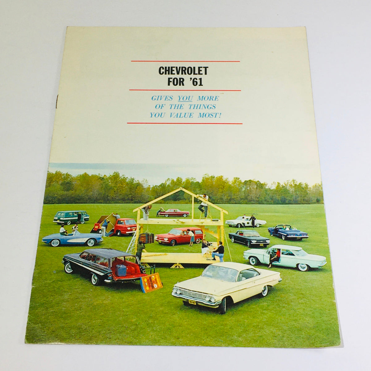 Cover of the 1961 Chevrolet Chevy Sedan 61PC-3 Dealership Car Auto Brochure Catalog, featuring various Chevrolet cars arranged on a grassy field with a house structure, promoting Chevrolet's offerings for 1961.