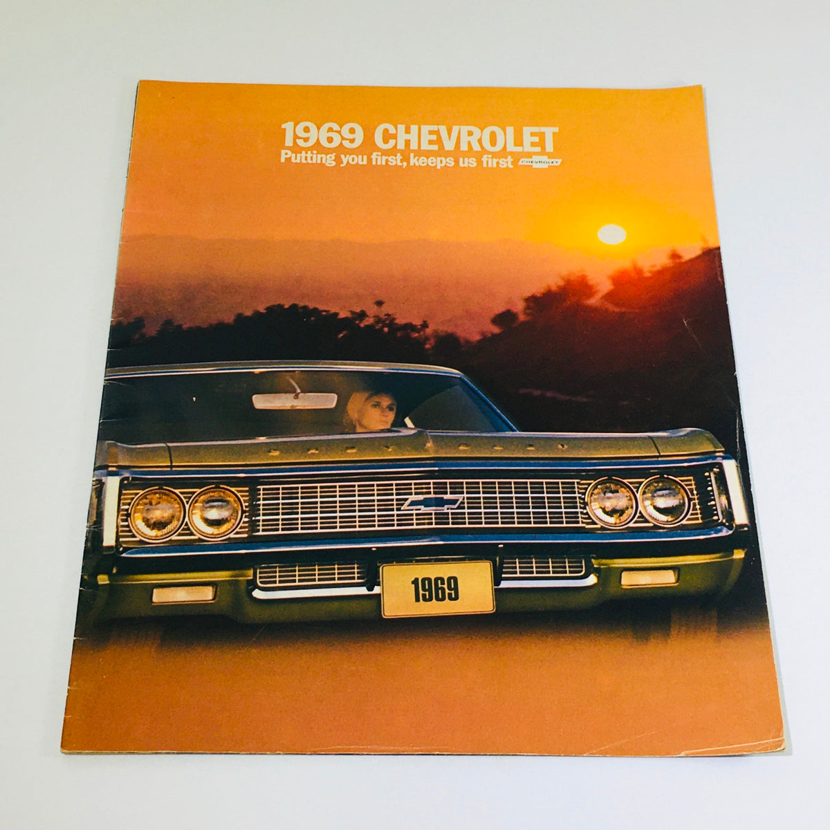 1969 Chevrolet Caprice Dealership Car Auto Brochure Catalog cover featuring a classic Chevrolet Caprice car with a scenic sunset background.