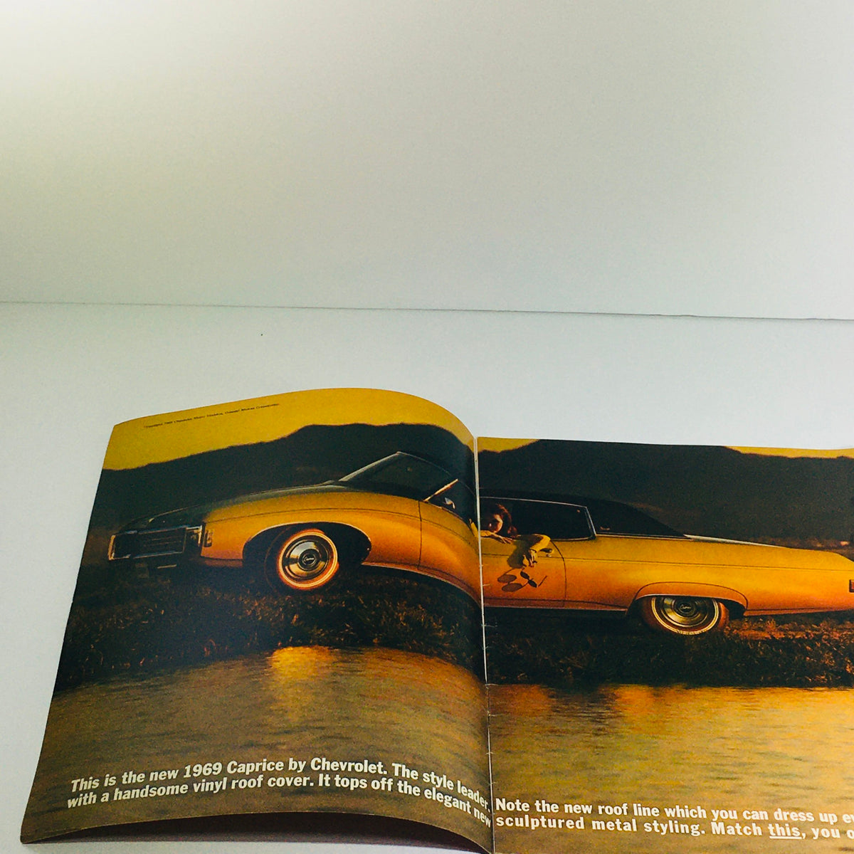 1969 Chevrolet Caprice Dealership Car Auto Brochure Catalog showcasing the golden Caprice model with a stylish vinyl roof, highlighting its elegant design and new features.