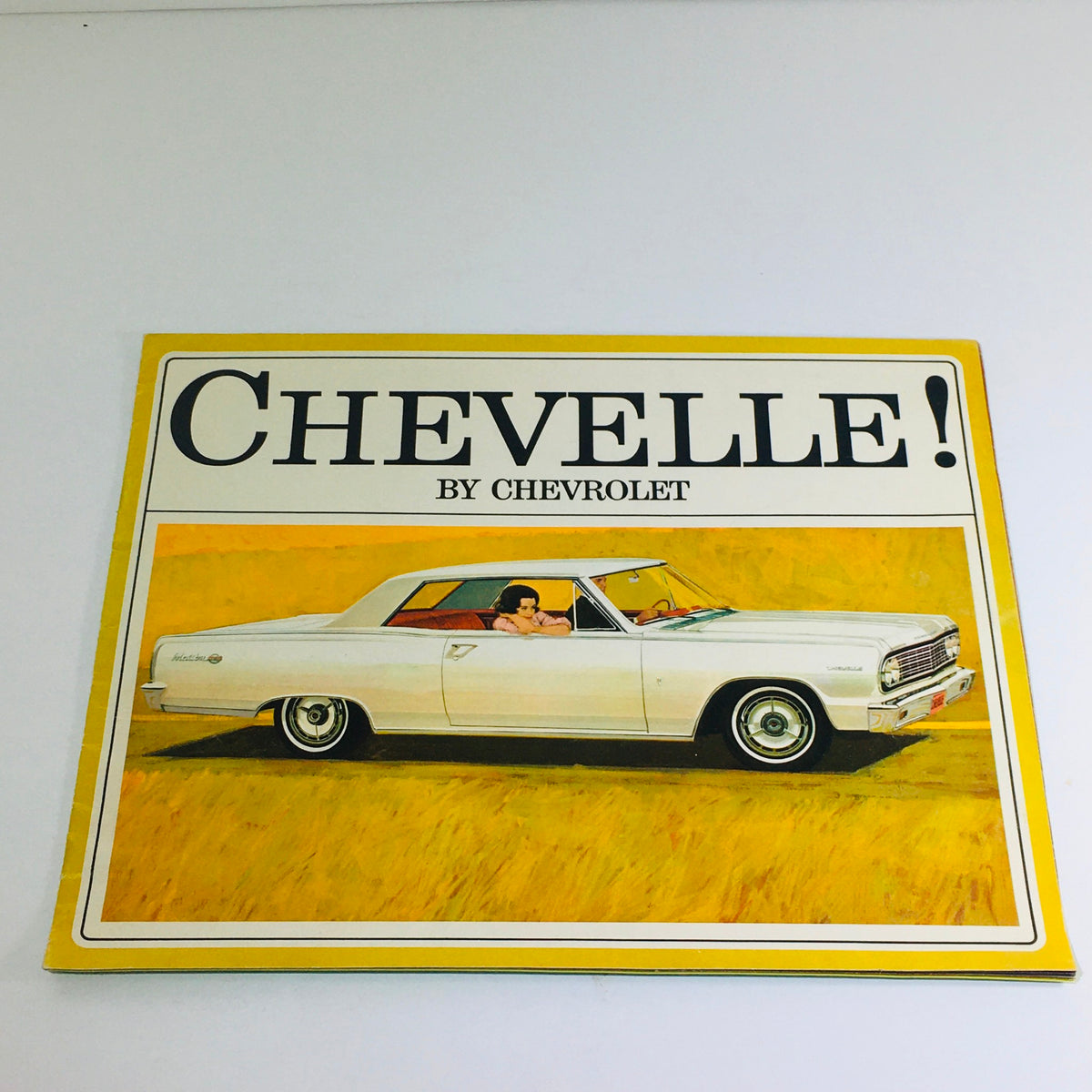 Cover of the 1964 Chevrolet Chevelle Malibu Sedan Dealership Brochure featuring a vintage illustration of a white Chevelle driving through a field.