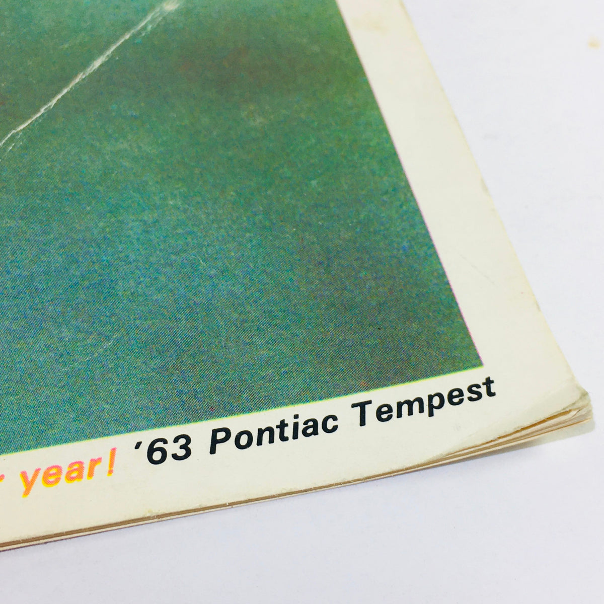 Close-up of the edge of a 1963 Pontiac Tempest brochure, featuring the text '63 Pontiac Tempest' in bold, highlighting its vintage aesthetics.