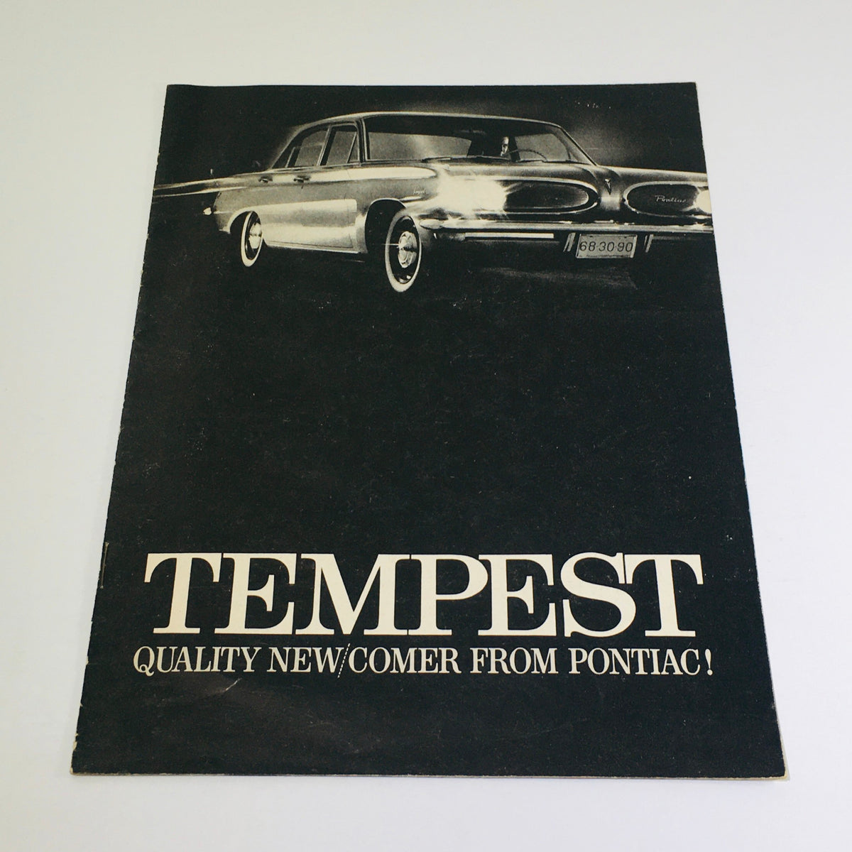 1961 Pontiac Tempest Showroom Dealership Car Auto Brochure Catalog cover featuring the stylish Pontiac Tempest with a black background and the words 'TEMPEST QUALITY NEW/COMER FROM PONTIAC!'