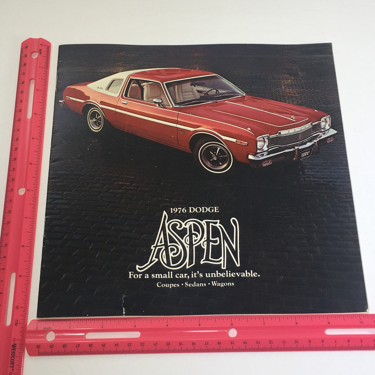 Front cover of the 1976 Dodge Aspen Coupes, Sedan, Wagons auto brochure catalog featuring a red Dodge Aspen with a tagline highlighting its compact design.