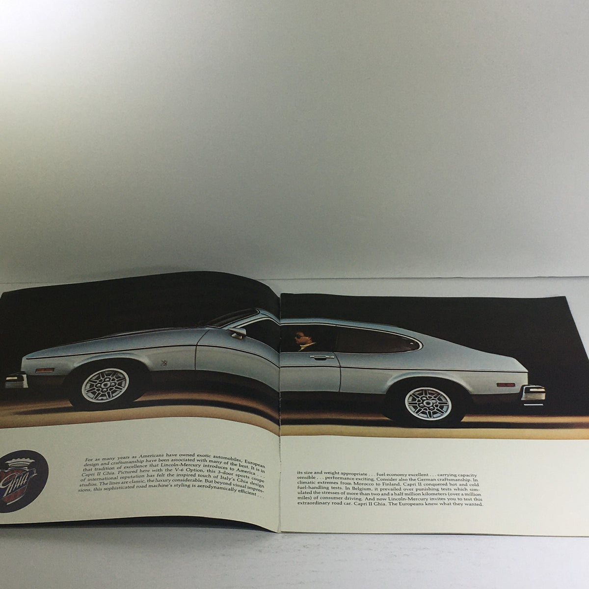 1976 Lincoln-Mercury Division Capri II Dealership Car Auto Brochure showcasing the Capri II model with a side view of the car and a driver inside, highlighting its vintage design and aesthetic appeal.
