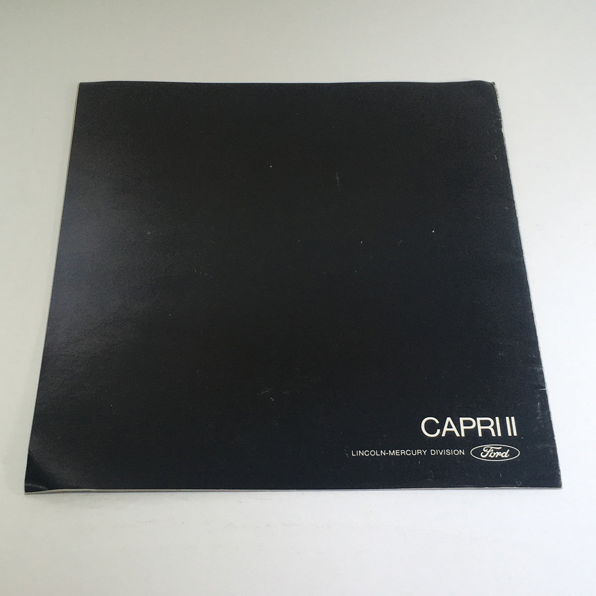 Cover of the 1976 Lincoln-Mercury Division Capri II Dealership Car Auto Brochure featuring a sleek black background with 'CAPRI II' text, representing the historic Lincoln-Mercury automotive catalog.