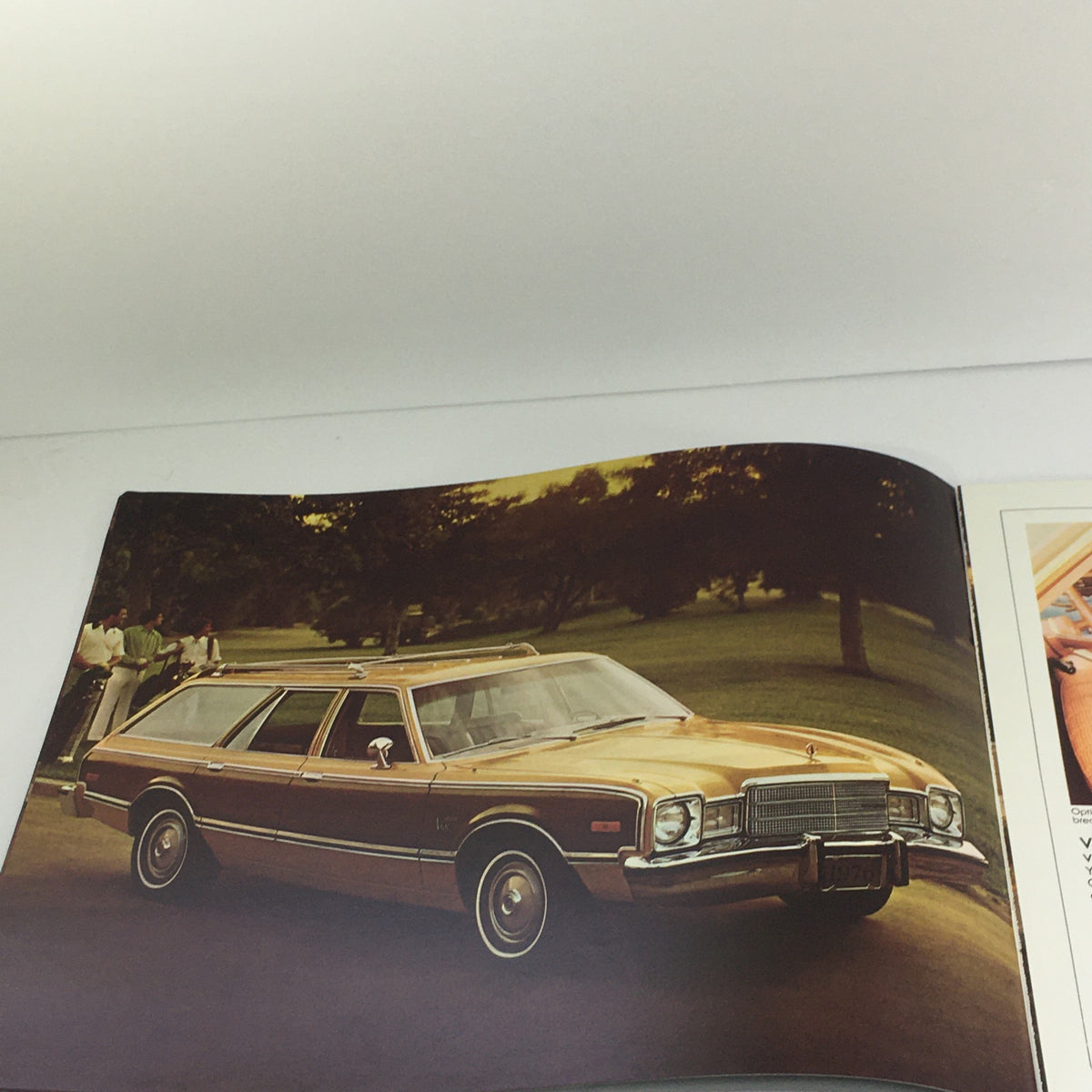 1976 Plymouth Volare Premier Custom Wagons features a vintage orange station wagon parked on a lawn, showcasing its unique design and classic style.