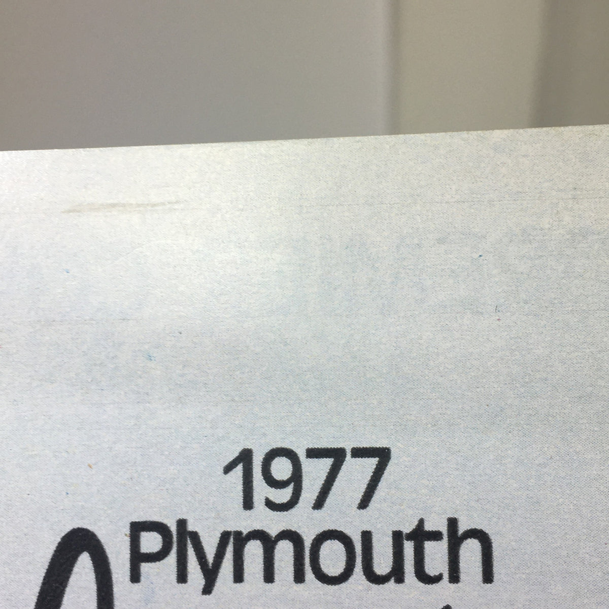 1977 Plymouth Volare logo from the dealership brochure, highlighting the model year and brand.
