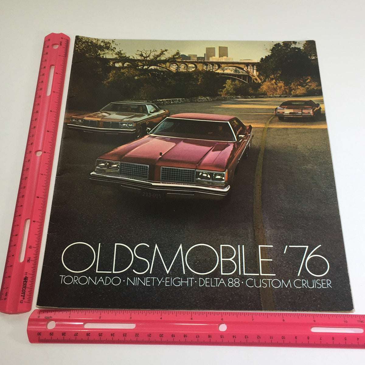 1976 Oldsmobile Toronado, Delta 88, Cruiser dealership car auto brochure catalog cover with three cars on a scenic road.